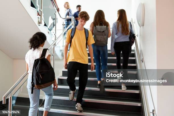 High School Students Walking On Stairs Between Lessons In Busy College Building